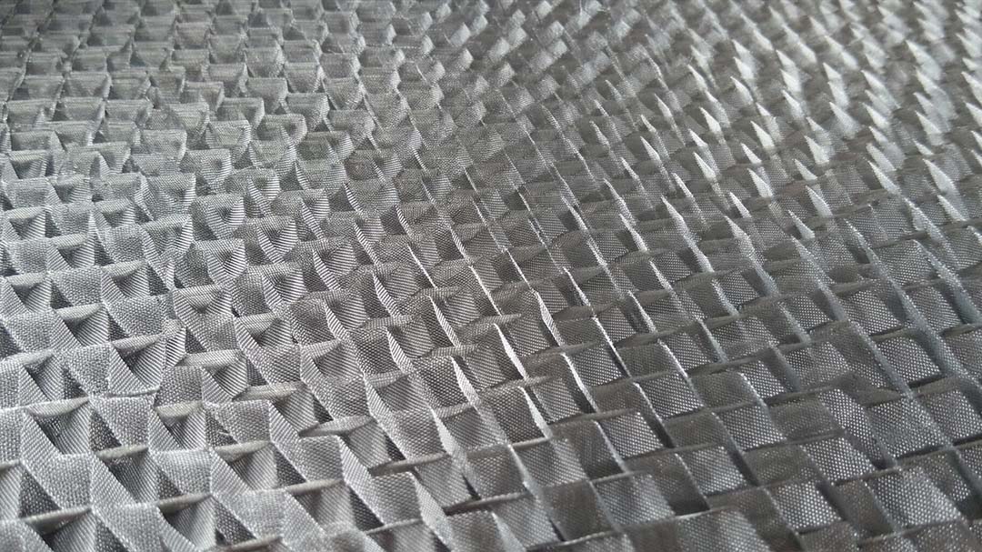 Macro of corrugated wire gauze sheet showing woven mesh texture and 30 degree ripple angle